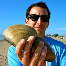 Nick holding clam shells on the beach